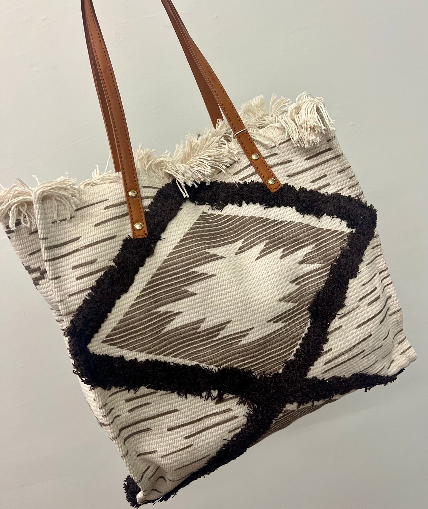 The Madison Fringe Tote is the perfect grab and go bag for the fall! The neutral colors are stunning and the fun pattern gives it just enough detail. The Tote even c